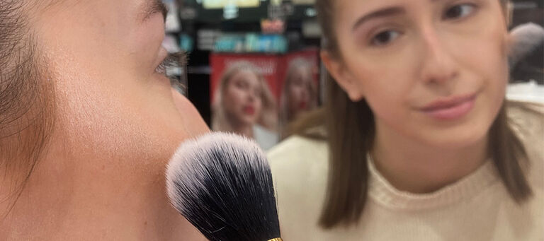 Gesicht mit einem Pinsel, der Highlighter aufträgt
